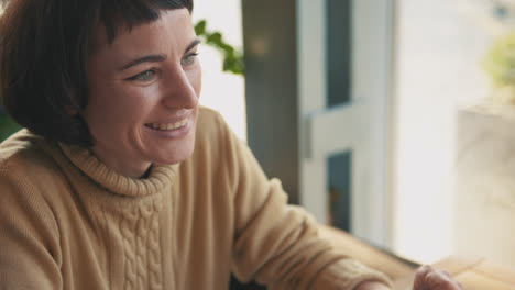 portrait of young woman talking to her friend in a coffee shop