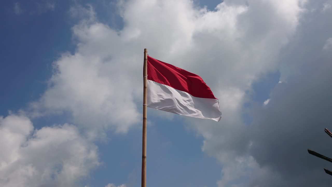 bandera indonesia ondeando en el fondo de las nubes del cielo azul