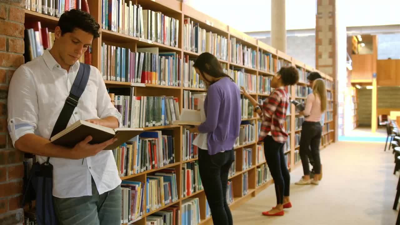 Student leaning on wall reading book
