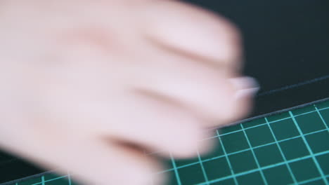 person hand wipes white line on leather with black napkin