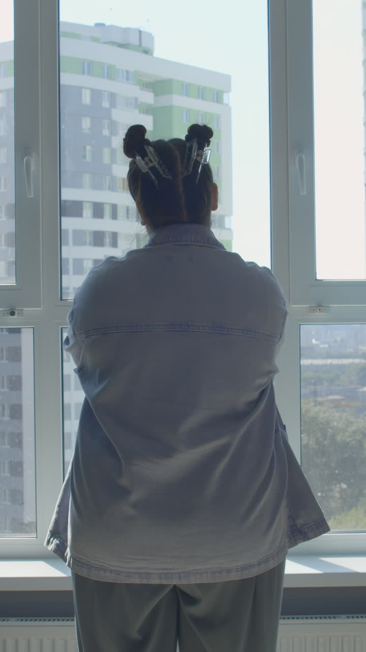 una mujer mirando por la ventana.