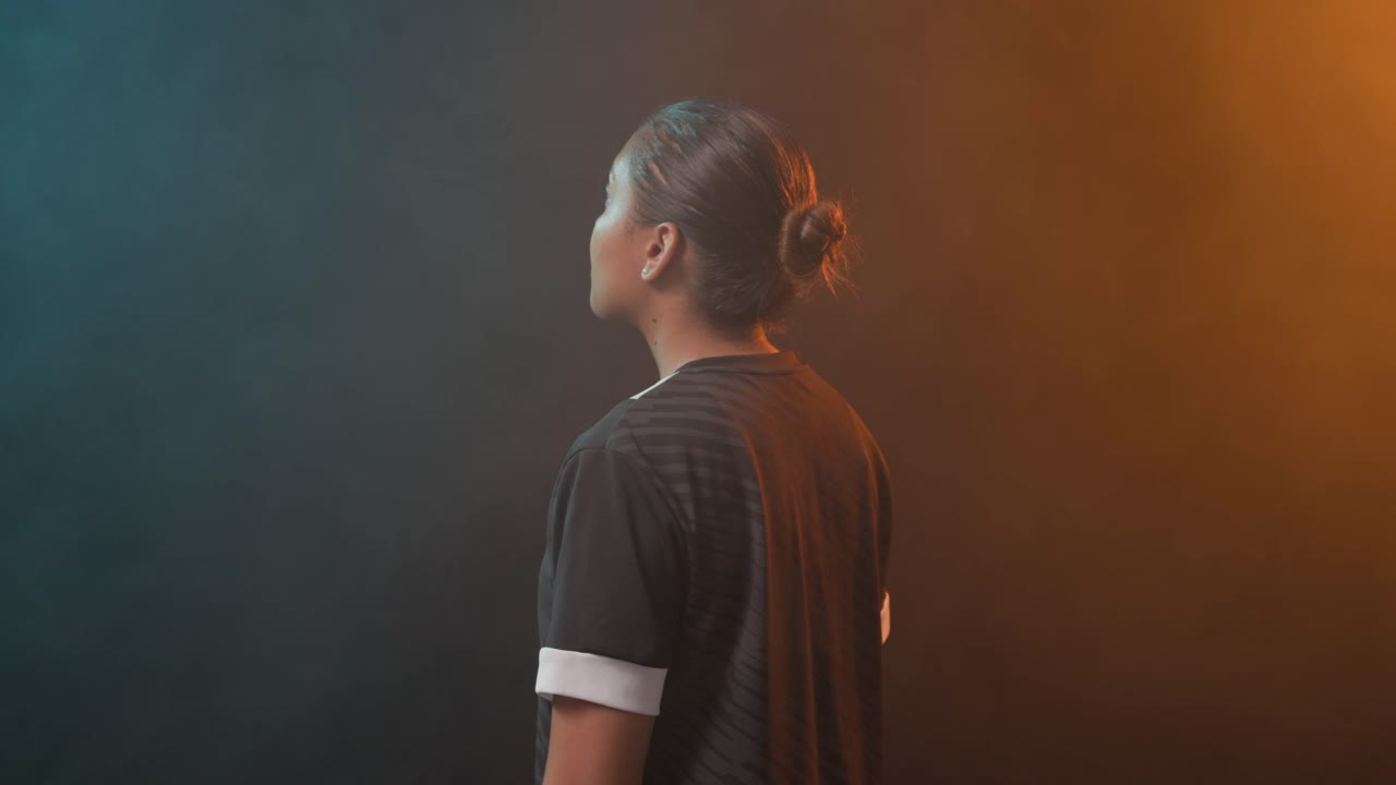 African American woman on cue standing in studio turning crossing arms showing jersey and teal haze