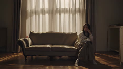 Woman Sitting on Sofa in Living Room