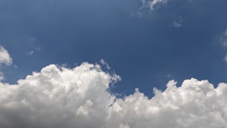 time lapse of the movement of white clouds in a blue sky, weather changing from sunny to slightly cloudy