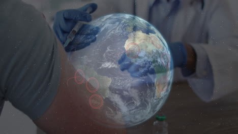 animation of globe with red location points over man receiving vaccination