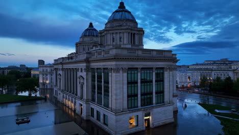 neoclassical building at dusk with wet ground reflections