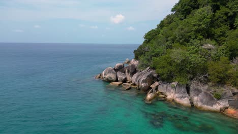 turquoise-water,-lagoon-Beach-on-Besar-Perhentian-island-with-a-lush-tropical-forest-in-the-background