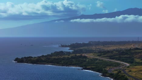 Beautiful-coastal-view-of-Maui-with-lush-greenery,-mountains,-and-a-coral-reef-under-a-bright-sky