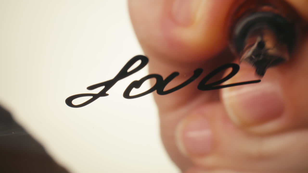 Close-up of Hand Writing 'Love' with Calligraphy Pen
