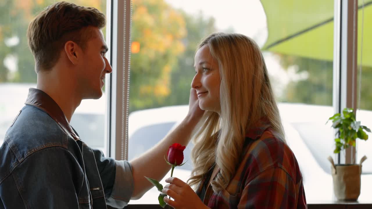 una joven pareja interactuando entre sí en un café 4k