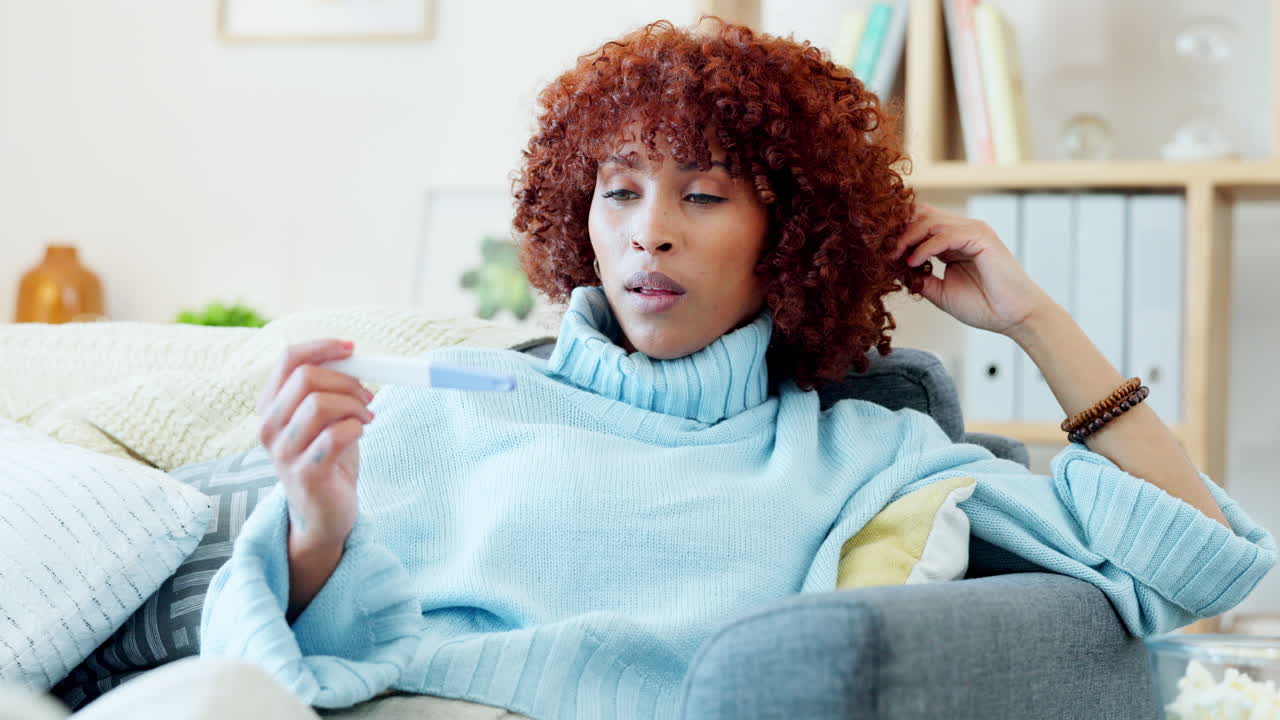 Young woman holding pregnancy test in hand