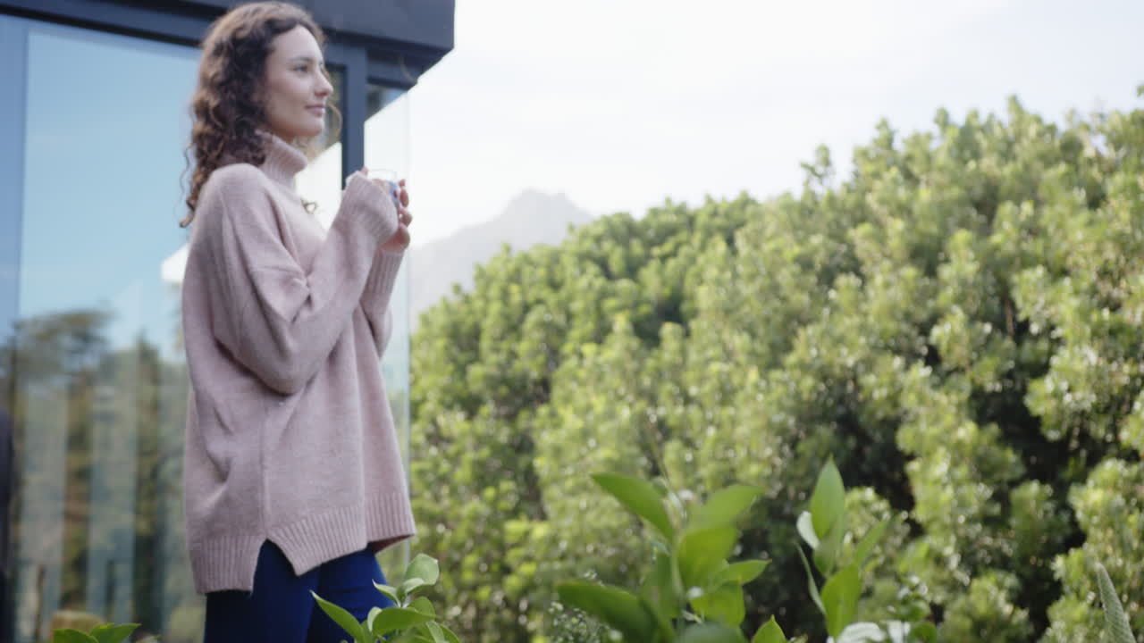 Enjoying peaceful moment, woman holding cup and standing on balcony, copy space