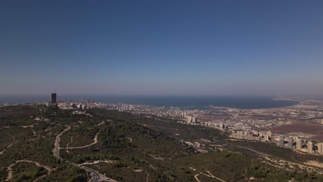 Static-view-of-a-busy-highway-near-a-coastal-city-with-skyscrapers-on-a-sunny-day,-Haifa,-Israel