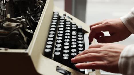 male hands type on keyboard of old manual typewriter