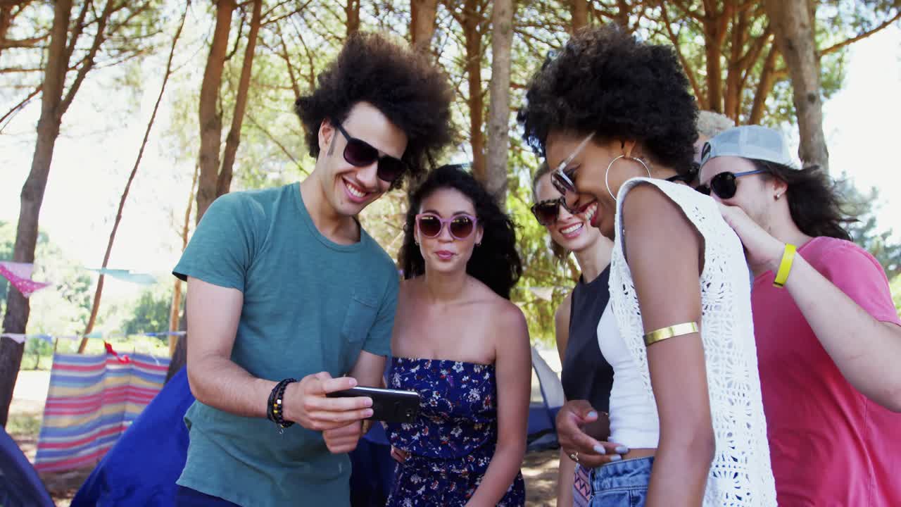 amigos mirando el teléfono móvil en el parque 4k