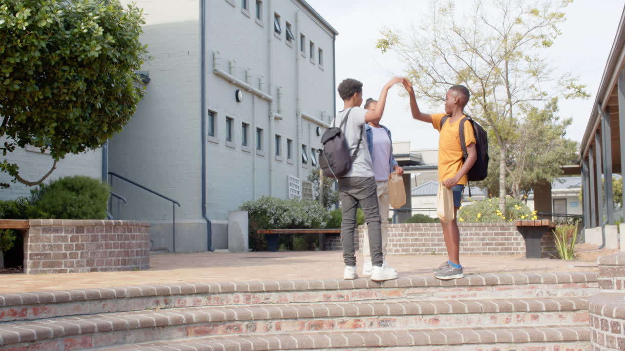Multiracial students with backpacks walking up outside school, enjoying conversation, copy space