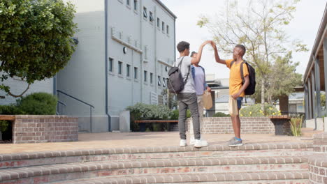 multiracial students with backpacks walking up outside school, enjoying conversation, copy space