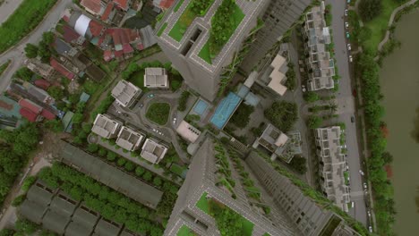 top-down aerial view of high-rise buildings in hanoi, vietnam, with lush greenery on rooftops, embodying the concept of a modern urban jungle