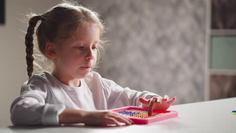 Una-Niña-Inspirada-Aprende-A-Contar-Con-Un-ábaco-De-Juguete-En-El-Escritorio