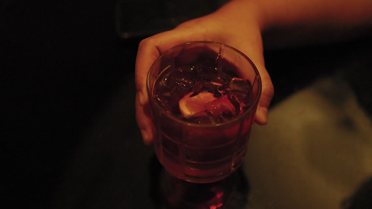 Mano che tiene un cocktail Negroni a Bangkok