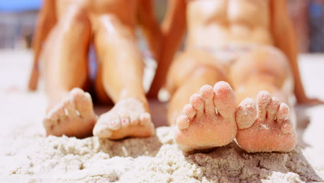 women's feet in the sand