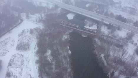 toma aérea de un puente de vías de tren que cruza el río boise durante una ventisca