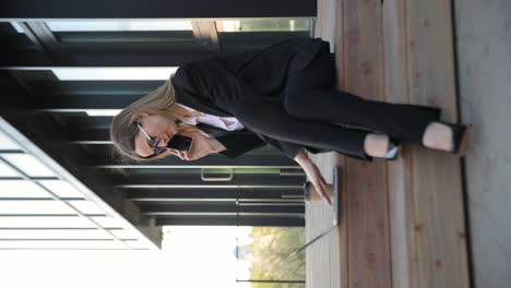 a professional woman in a suit sits on a bench foc 4k 2025 08 05 01 08 21 utc (1).mov | beautiful, building, business, call