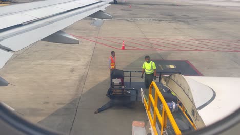 airport ground crew loading luggage onto an airplane