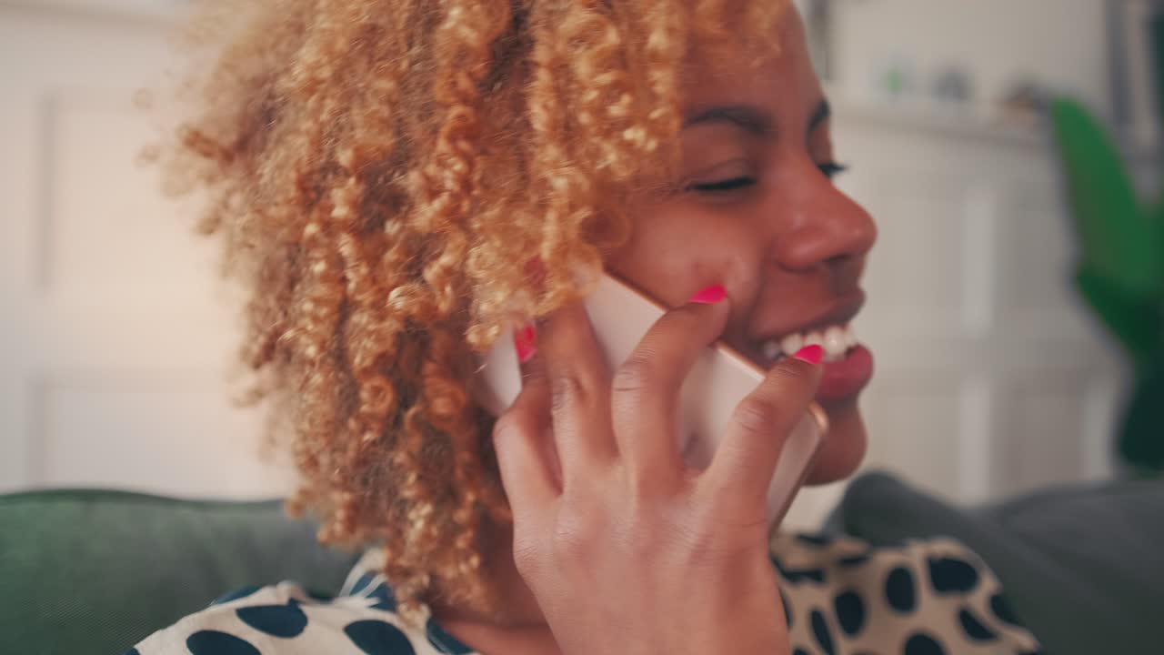 Happy young african american woman joyfully talking on mobile phone