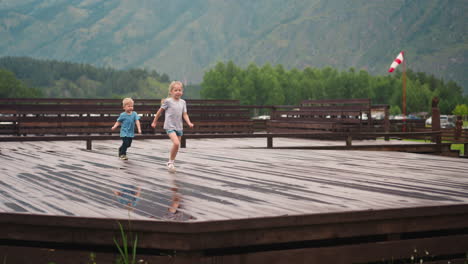 Little-children-run-playing-together-along-large-platform