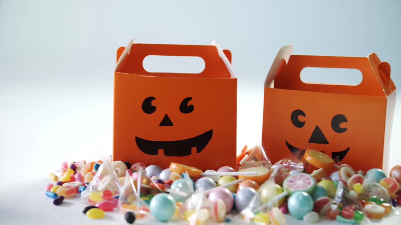 Halloween box with various candies on white background 4k