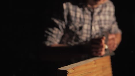 wood shavings ejecting from carpenters hand planer, medium shot