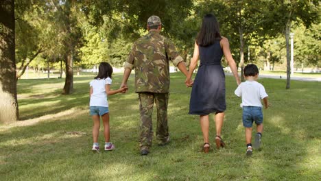 military man and his family enjoying leisure time in park