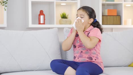 girl child covering his mouth and nose with a tissue while coughing.