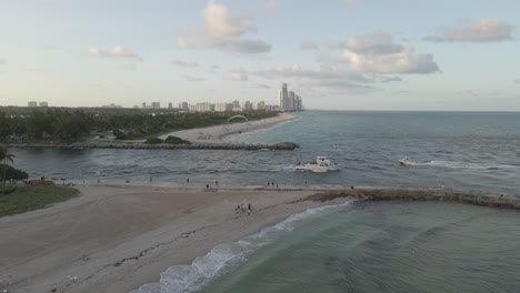 Ships-motoring-below,-paramotor-flies-over-Miami-beach-channel-inlet