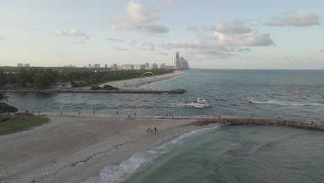 barcos motorizando debajo, paramotor vuela sobre la entrada del canal de miami beach