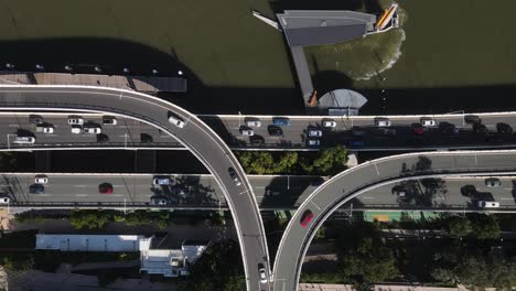 the network of intertwining roads and overpasses of the riverside expressway built next to the brisbane river. aerial view