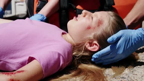 paramédicos examinando a una chica herida