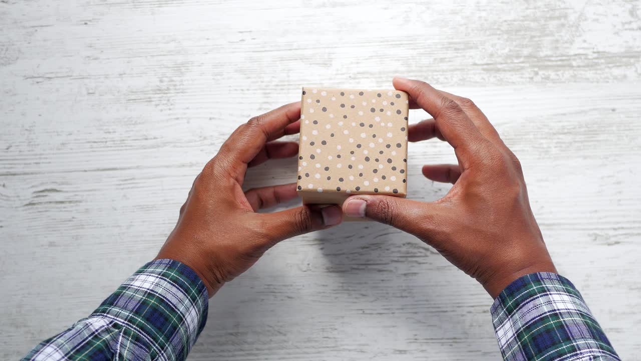 선물 상자를 열고 있는 사람