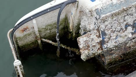 barco abandonado e inclinado en un muelle