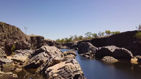 drone volando por encima y entre rocas mientras vuela a través de un desfiladero rocoso