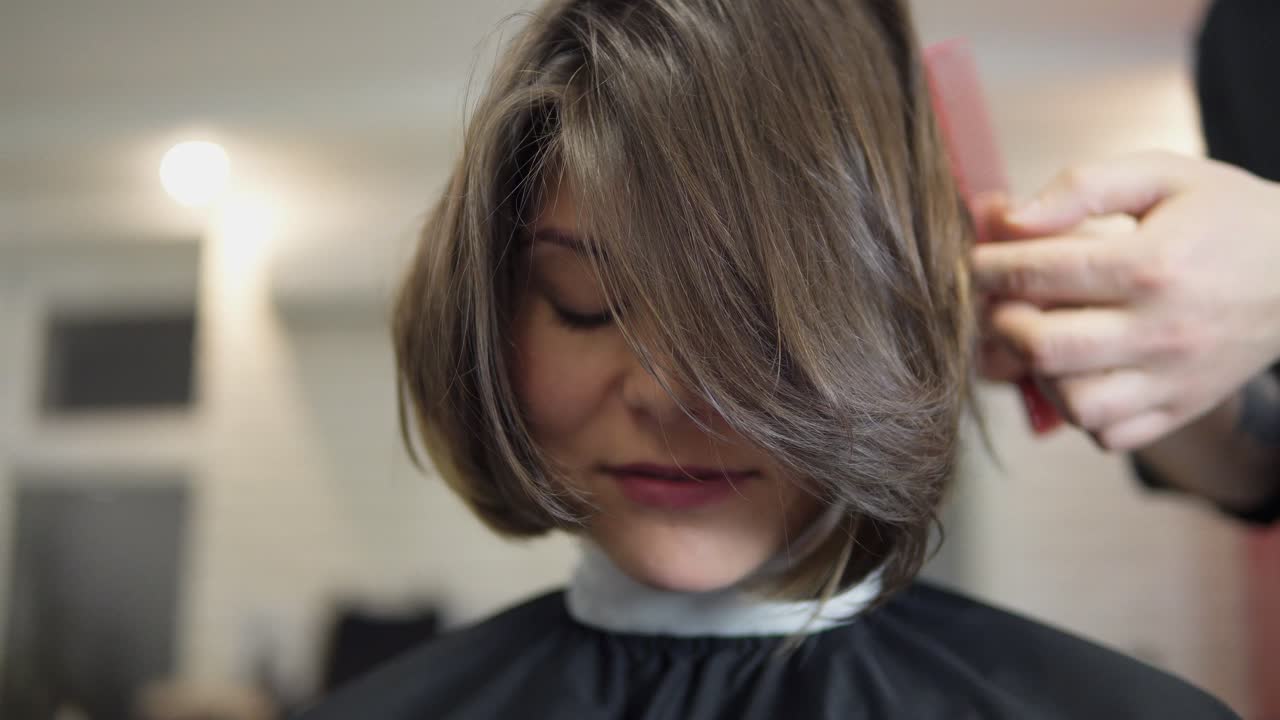 peluquero profesional, estilista peinando el cabello de la cliente femenina y usando barretas para arreglar el peinado en el salón de peluquería profesional. concepto de belleza y cuidado del cabello