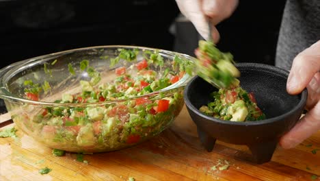 putting avocado jalapeño salsa in an authentic style mexican bowl.