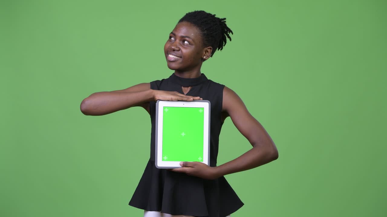 Ung smuk afrikansk forretningskvinde viser digital tablet