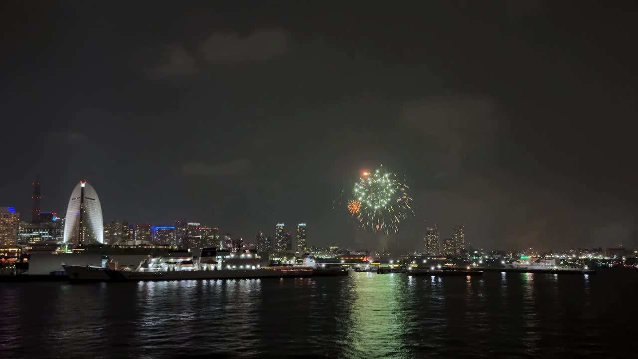 Fireworks over city skyline at night during Yokohama Port Festival celebration