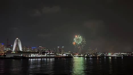 fireworks over city skyline at night during yokohama port festival celebration