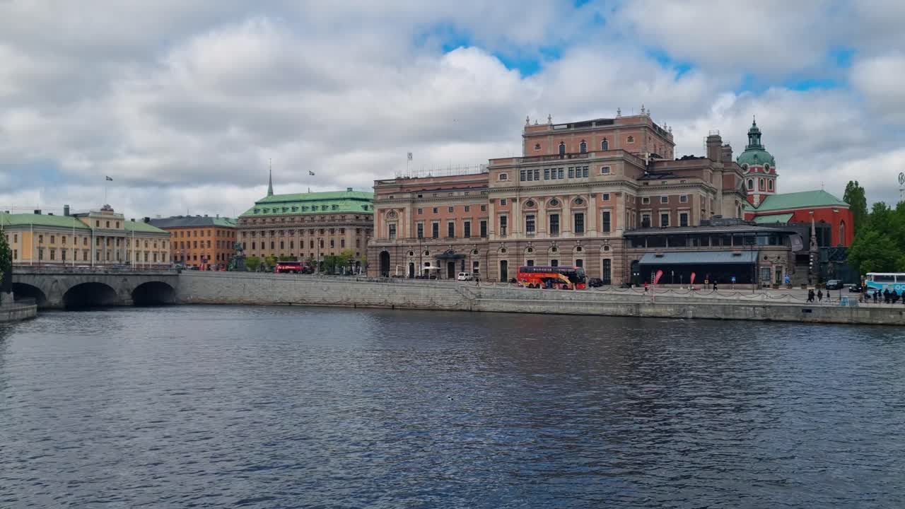 View of the Royal Swedish Opera and the Norrström river in central Stockholm, Sweden, on a cloudy spring day, with calm water reflecting the grey sky