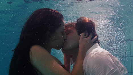 Romantisches-Paar,-Das-Sich-Unter-Wasser-Im-Schwimmbad-Küsst-Und-Bekleidet-Ist.-Verliebte-Junge-Menschen-Genießen-Innige-Küsse.-Liebende-Sind-Unter-Wasser-Und-Schwimmen-Mit-Blasen-In-Leidenschaftlicher-Intimität