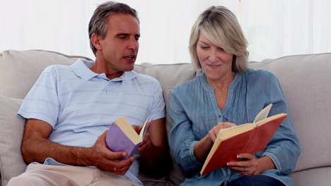 personas maduras leyendo libros en el sofá