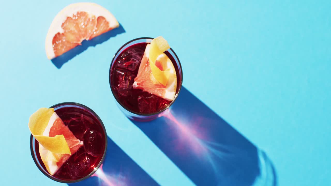 Close up of drinks with grapefruit over blue background